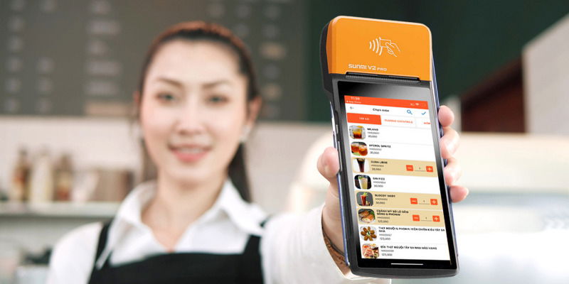 Nhân viên thanh toán bằng máy POS cầm tay